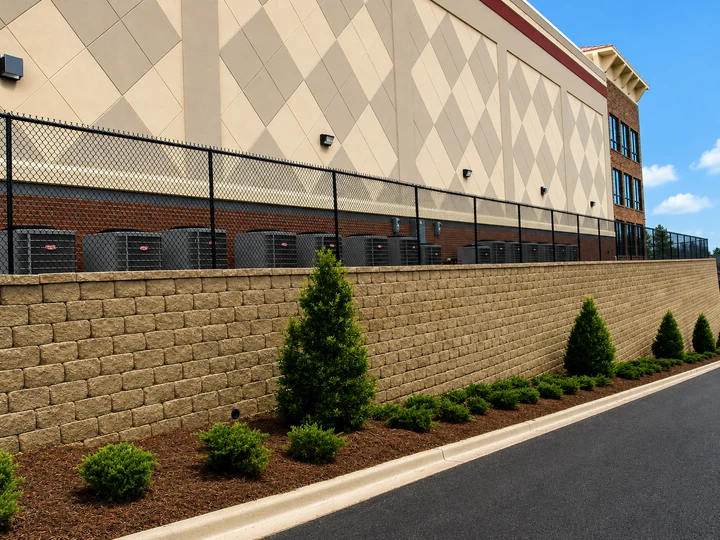 Chain link fence atop a retaining wall at an industrial building